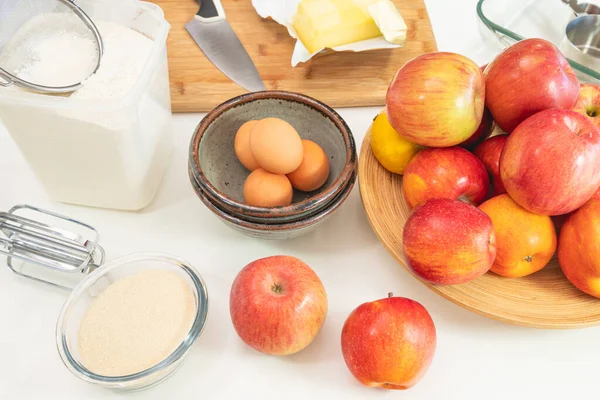 Baking apple pie. Apples, eggs, sugar, butter, flour, and some ingredients close up on a kitchen table