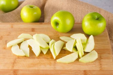Apple slices close-up on a wooden cutting board. Apples close-up on a kitchen table