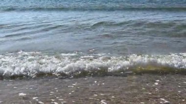 Küçük okyanus dalgaları kumlu sahilde kırılıyor. Yüksek kalite 4k görüntü