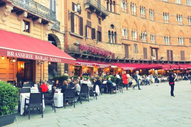Turistler Siena İtalya Piazza del Campo meydanda tadını çıkarın. Siena'nın tarihi merkezini Unesco tarafından Dünya Mirası ilan edildi