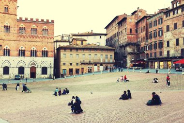 Turistler Siena İtalya Piazza del Campo meydanda tadını çıkarın. Siena'nın tarihi merkezini Unesco tarafından Dünya Mirası ilan edildi