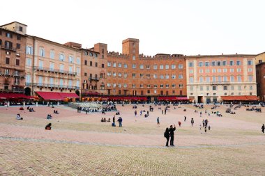 Turistler Siena İtalya Piazza del Campo meydanda tadını çıkarın. Siena'nın tarihi merkezini Unesco tarafından Dünya Mirası ilan edildi