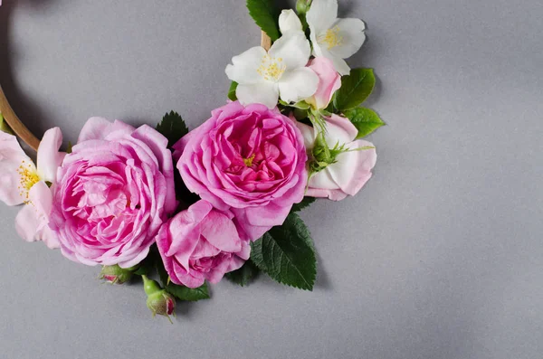 Blumenrahmen. Rosenblüten auf grauem Grund. flache Lage — Stockfoto
