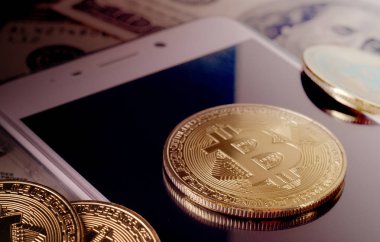 Fiziksel altın Bitcoin para dolar faturaları ve smartphone mor bir arka plan üzerinde karşı.