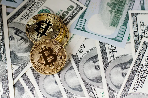 Oro físico Bitcoin Moneda contra billetes de dólar y teléfono inteligente sobre un fondo morado . — Foto de Stock