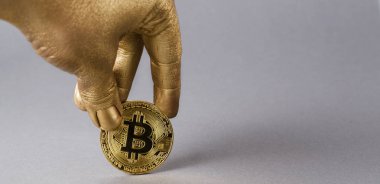 Cryptocurrency bitcoin fiziksel sikke altın el tutar.