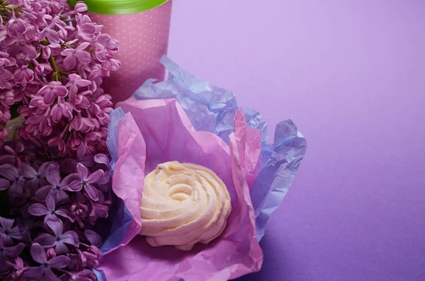 Eten foto van zelfgemaakte zephyr, marshmallow in violet inpakpapier en koffie gaan cup. Zoete dessert op een roze achtergrond. — Stockfoto