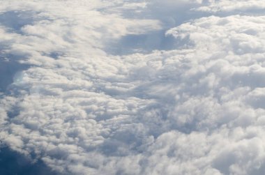 Uçak ışığı görünümü kabarık bulutlar ve mavi gökyüzü.