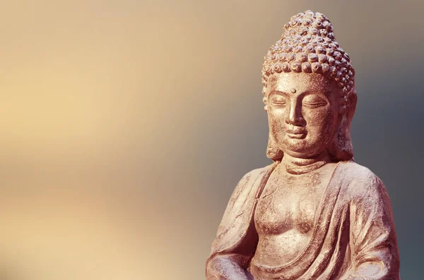 Statua di Buddha seduto in meditazione posa contro sfondo dorato sfocato . — Foto Stock