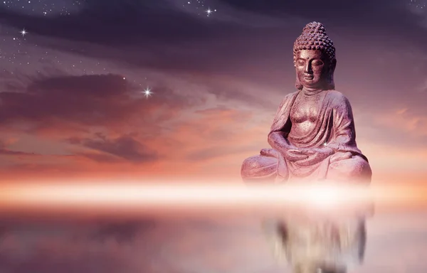 Boeddhabeeld zittend in meditatie houding tegen zonsondergang hemel met gouden tinten wolken. — Stockfoto
