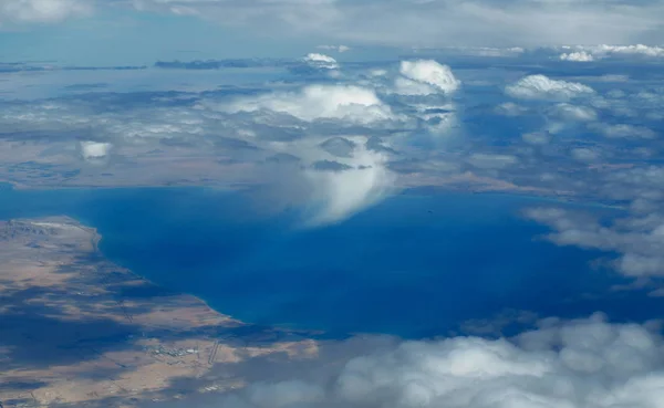 Amazing aerial view view fluffy clouds above Sinai, Sharm El Sheikh, bright blue sea and sand islands in the Red sea. Airplane view. — Stock Photo, Image