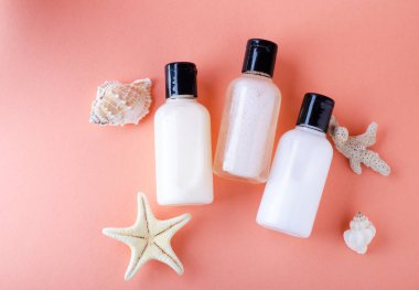 Canlı Mercan rengi ile bir arka planda Kozmetik Şişeler. Şampuan, saç kremi ve vücut losyonu şişeleri bileşimi.