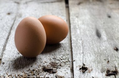 Bir vintage rustik ahşap tahta üzerinde Tavuk kahverengi yumurta.