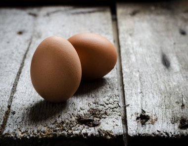 Bir vintage rustik ahşap tahta üzerinde Tavuk kahverengi yumurta.