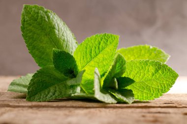 Rustik ahşap arka plan üzerinde taze yeşil nane yaprakları.