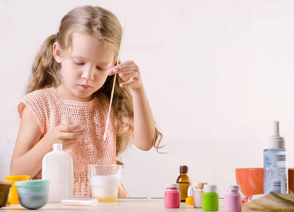 Adorable niña haciendo juguete de limo, mallas ingredientes para todo el mundo popular juguete hecho a sí mismo . — Foto de Stock