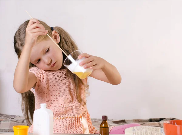 Schattig klein meisje maken slijm speelgoed, mazen ingrediënten voor wereldwijd populaire zelfgemaakte speelgoed. — Stockfoto