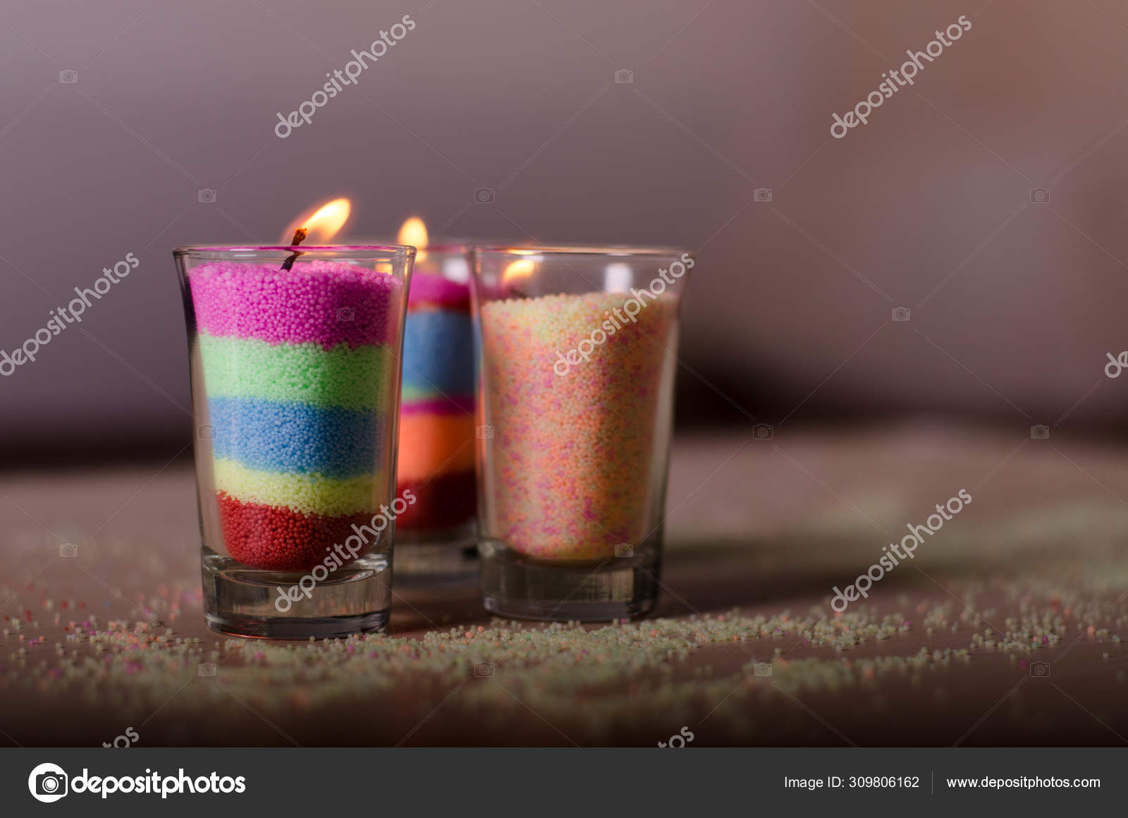 Homemade candles from colored granulated wax in a glasses. Stock