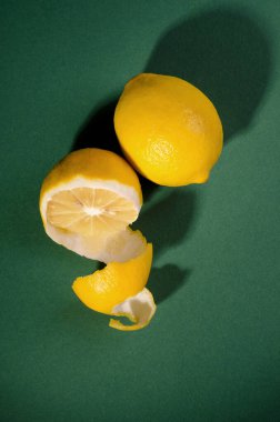 Yeşil arka planda taze sulu limon. Uzun gölgeli minimalist yemek posteri.