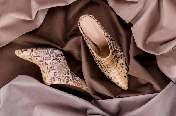 女用的高跟鞋是用Python皮革制成的 豪华蛇皮皮鞋广告背景 — 图库照片