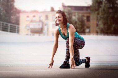 Şehir stadyumunda tüm sezon boyunca kırmızı pistte başlangıç pozisyonunda duran genç bayan..
