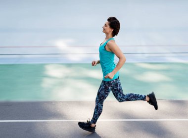 Stadyumda bütün sezon boyunca kırmızı pistte koşan genç bir bayan..