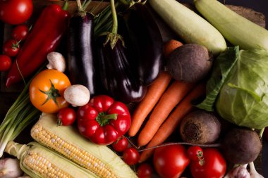 Ahşap bir masada taze sebzelerle dolu karanlık huysuz bir hayat. Sağlıklı organik yerel gıda bakkal geçmişi.