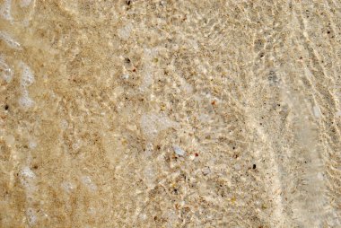 Deniz su dalgaları ile kum plajı kabarcıklar yukarıya kapatmak