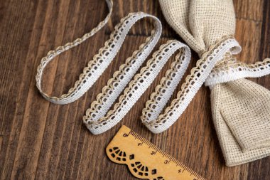 Kırsal kesim tarzı beyaz keten şerit bantlar. Pamuk eko ahşap zemin üzerinde doğal.