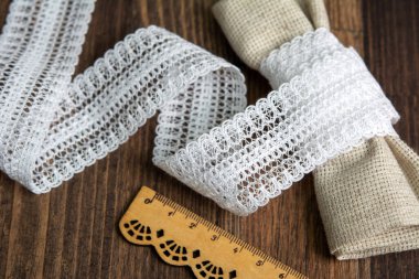 Kırsal kesim tarzı beyaz keten şerit bantlar. Pamuk eko ahşap zemin üzerinde doğal.