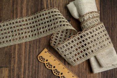 knitted beige openwork linen ribbon tapes in rural style of rustics cotton eco natural on wood ground