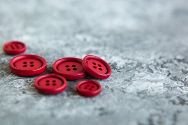 Beton arka planda kırmızı mat düğmeleri, makro bokeh. güzel nakış işi