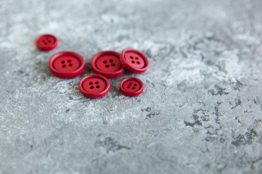 Beton arka planda kırmızı mat düğmeleri, makro bokeh. güzel nakış işi