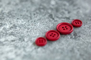 Beton arka planda kırmızı mat düğmeleri, makro bokeh. güzel nakış işi