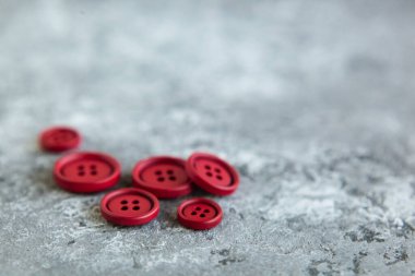 Beton arka planda kırmızı mat düğmeleri, makro bokeh. güzel nakış işi