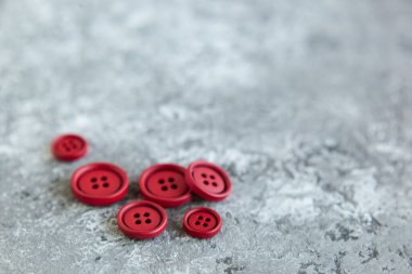 Beton arka planda kırmızı mat düğmeleri, makro bokeh. güzel nakış işi