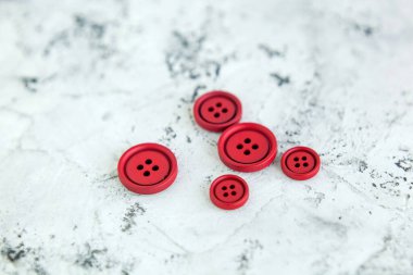 Beton arka planda kırmızı mat düğmeleri, makro bokeh. güzel nakış işi
