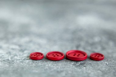 Beton arka planda kırmızı mat düğmeleri, makro bokeh. güzel nakış işi