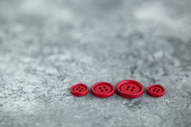 Beton arka planda kırmızı mat düğmeleri, makro bokeh. güzel nakış işi