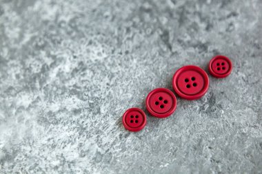 Beton arka planda kırmızı mat düğmeleri, makro bokeh. güzel nakış işi