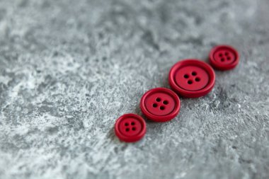 Beton arka planda kırmızı mat düğmeleri, makro bokeh. güzel nakış işi