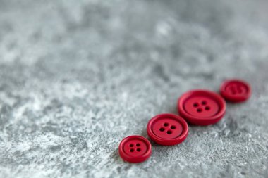 Beton arka planda kırmızı mat düğmeleri, makro bokeh. güzel nakış işi