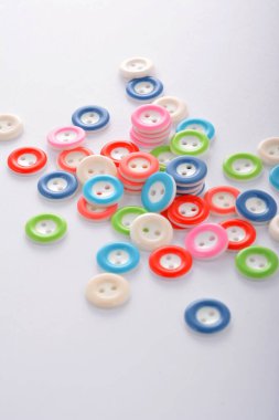 Beyaz arka planda renkli düğmeler yığını. terzilik ve dikiş için kullan