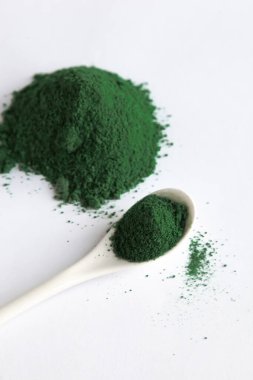 Beyaz kaşık klorella ya da spirulina yosunlu ya da matcha, açık arkaplanlı. Süper yiyecek konsepti tozu.