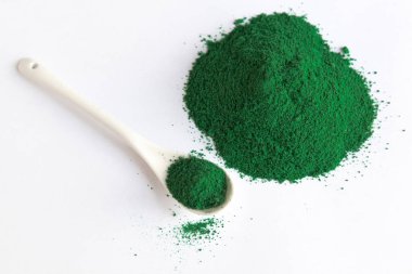 Beyaz kaşık klorella ya da spirulina yosunlu ya da matcha, açık arkaplanlı. Süper yiyecek konsepti tozu.