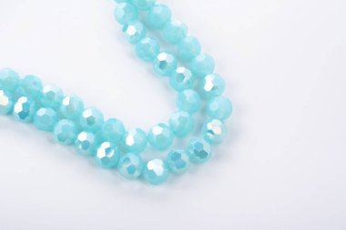 Güzel açık mavi cam parıltılı kristal boncuklar beyaz arka planda. Boncuklu mücevherler için kullan. Metin için boşluk