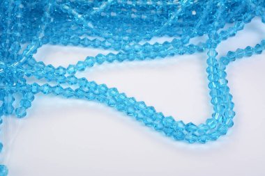Güzel açık mavi cam parıltılı kristal boncuklar beyaz arka planda. Boncuklu mücevherler için kullan. Metin için boşluk
