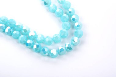 Güzel açık mavi cam parıltılı kristal boncuklar beyaz arka planda. Boncuklu mücevherler için kullan. Metin için boşluk