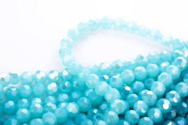 Güzel açık mavi cam parıltılı kristal boncuklar beyaz arka planda. Boncuklu mücevherler için kullan. Metin için boşluk