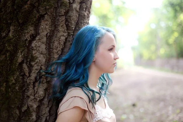 在夏日的阳光森林里 一个年轻的 梦幻般的 留着蓝色头发的女孩 美丽的女人 有中性的箭妆容 — 图库照片